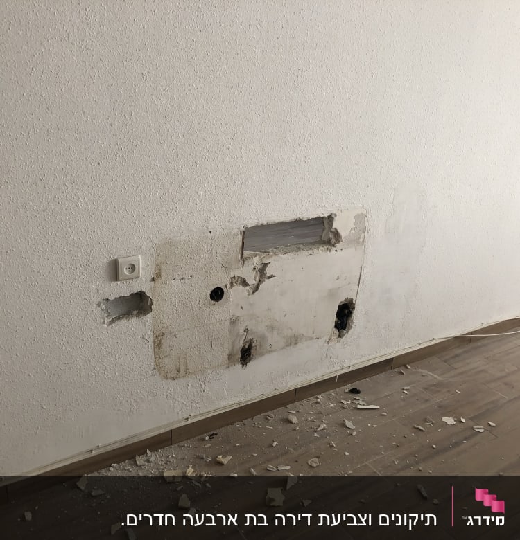 קיר עם חור ותיקונים, שברי טיח על הרצפה